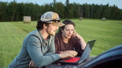 Two people looking at laptop screen.