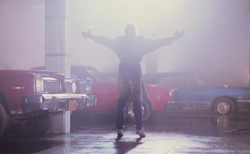 back view of man in silhouette with arms raised and outstretched as brilliant light shines