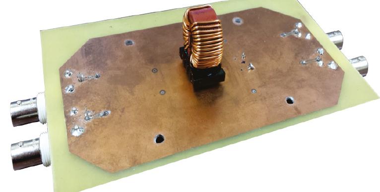 Figure 10. A 2.2mH CMC, listed in Table 2 as WURTH ELEKTRONIK 744824622, mounted on a PCB fabricated to check the impact on [syeM| of the capacitive coupling of the signal traces to the return plane.  frequencies (well below resonance) is the same for these three situations. However, Figure 11 also reveals that at high frequencies there exists a shift in the frequency of resonance of SYPM. Compared to the isolated case, the frequency of resonance is slightly lower when the RP is not grounded and slightly higher when the RP is grounded. These results are consistent with the analysis presented in Section 2.2. We have obtained similar results for all the CMCs in Table 2. 