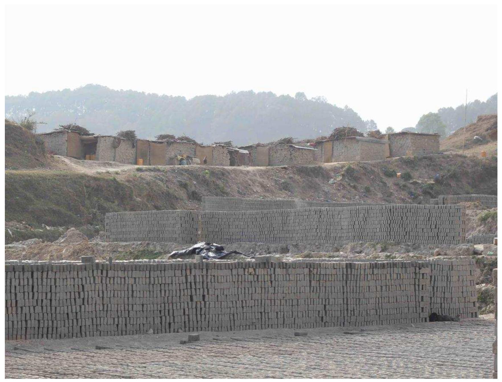 Figure 7: Bajra brick kiln in Lalitpur where 14-16 year-old girls work (in the backgrounc lie the shacks where they live).  For the most part, out-of-school girls who engage in income-generating activities outside agriculture engage in lower-skilled work such as carrying stones and bricks and domestic help. Out-of-schoo| girls in Kaski District and Kathmandu Valley are engaged in this kind of work (see Figure 7, below) 