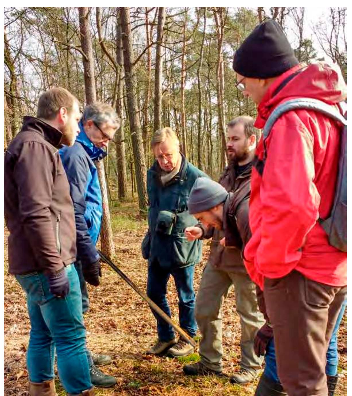 Figure 8. The validation of a new potential barrow through hand corings in early 2019, from left to right: R. Kramer (Erfgoed Gelderland), M. Wispelwey (Samenwerkingsverband Noord Veluwe), G. Scheltema (Archeologische Werkgroep Nederland), Q.P.J. Bourgeois (Leiden University), W.B. Verschoof-van der Vaart (Leiden University), and K. Lambers (Leiden University) (Photograph by E. Kaptijn (Erfgoed Gelderland)).  a aaa I I a a aN a ay aa a  It is recognized that the last validation step within the process, involving minimal invasive techniques, is a complex affair, which requires a certain degree of experience (see Section 2.3). Furthermore, invasive archaeological research is strictly regulated and restricted to ‘professional archaeologists’ by Dutch heritage laws [102]. Therefore, this step within the validation will be conducted by heritage managers and/or academic researchers assisted by citizen researchers and/or students in so-called coring campaigns. After successful test runs in early 2019 (Figure 8), both the field expeditions and the coring campaigns will take place in summer and autumn, building on previous collaboration with regional heritage managers and citizen researchers in the Veluwe project. 