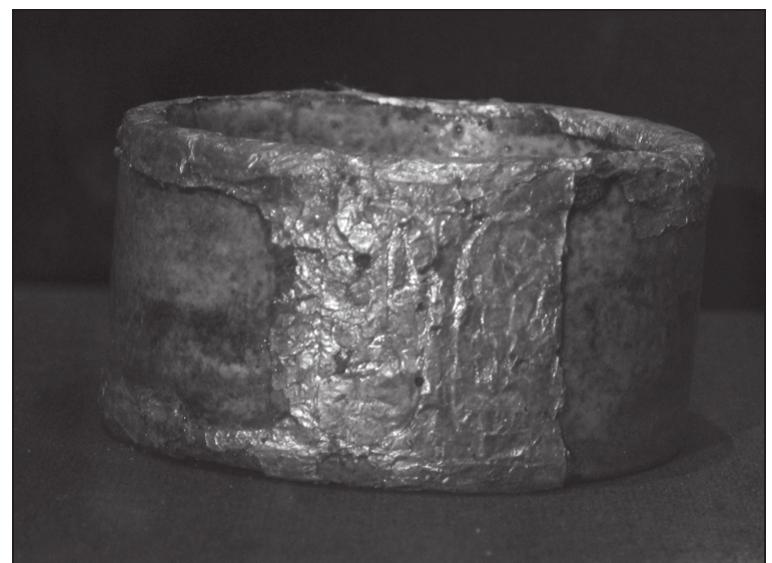 Fig. 25: Broad Bracelet with Cartouches of Akhenaten, JE 62415 (Mohamed Osman)  —_ ee Ae Fe Tn eS  so this is clearly incorrect.6> Carter 620(41)  is a blue faience bracelet, but Carter’s description says “The cartouche very roughly incised onto the gilt-stucco, (?) var. of the prenomen and nomen of Smenkh-ke-Re.|[sic]’ He also says that it is in a very bad state of preservation. According to the JE and SR, JE 62415 is inscribed with the cartouches of Akhenaten. It is difficult to read these now (see Figure 26), but this bracelet is missing the gilt on the bottom to the proper left of the gilt band containing the cartouches, as indicated in Carter's card for Carter 620(40),°° which is inscribed with the cartouches of Akhenaten (Neferkheperure-waenre Akhenaten, see Figure 26). On the Griffith web site, Carter 620(40) is cross-referenced to JE 62417 = Exhibition 590 (see below, # 20); this is incorrect. JE 
