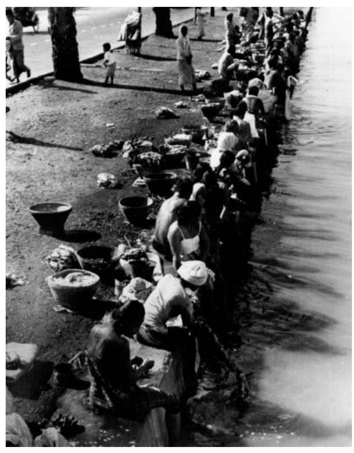 Indonesia, Sanitation (1950-1959): Women wash clothes in a Jakarta canal. Further on, people will draw their drinking water from the same source.