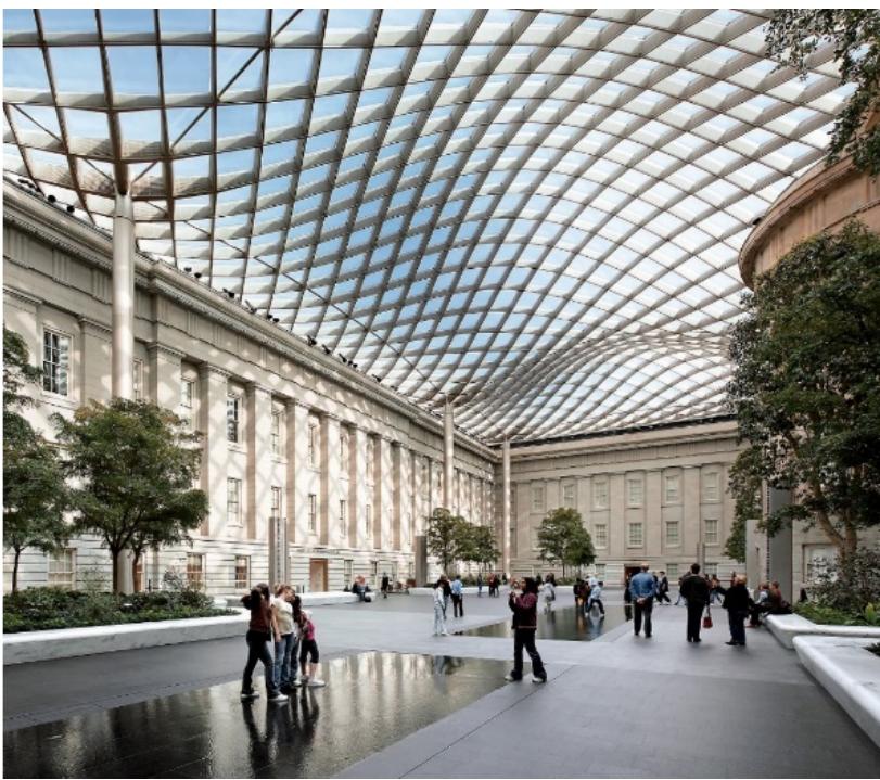 This design is a courtyard in a historical building and is located in a built environment. In YouTube videos of this design, the water feature is directed horizontally and vertically and appeals to the three senses. The water is placed on the ground in bands (water scrims) that do not fill a volume. Humans can experience water by touching this band. The process of removing rainwater from the roof structure, which is the main character of  the design, also emphasizes the sound of water. Rainwater on the wave-shaped glass structure passes away through the columns that carry the structure (Figure 2). During this transition, the flow of water is heard through  the columns. At the same time, rainwater can be heard in the glass structure on the roof.  Figure 2. The Robert and Arlene Kogod Courtyard at the Smithsonian Institution, Photography: Chuck Cho 