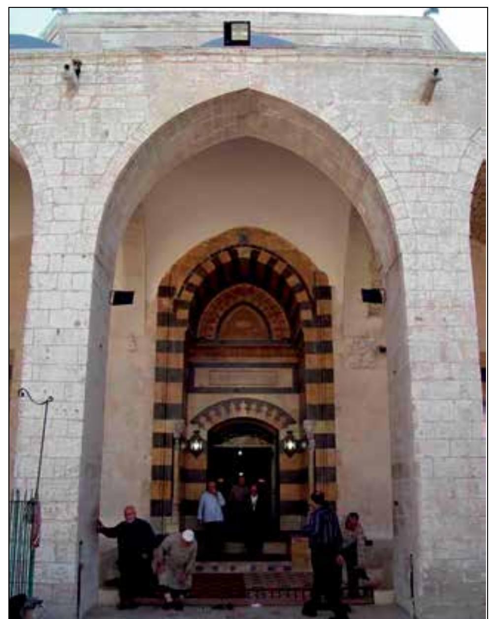 The tympanum of the niche is covered by carved stone ornaments and mugarnas strips recalling the portal of the Mamluk Oghul Bek mosque (1480) in Aleppo. The windows of the prayer hall are also built with polychrome masonry and surmounted by relieving arches.  The prayer hall is a domed cube with a five- sided apse on its southern side. The original dome was resting on eight arches and four squinches. The remains of the squinches at the hall’s corners have retained roundels and 3 rows of muqarnas corbelling. (Photo 11) The original dome covered an approximate area of 324 m2 which made it the largest among the other Ottoman domes in the city (David, 1991, p. 185). The rebuilt dome, however, was built raised on a drum pierced with 16 small windows. The drum itself is supported by four piers set directly into the hall with pendentives being used as transition elements. (Photo 12) The rest of the hall is covered by vaults.  Fe OE OE, ee Oe, Oe n,n ee a, [eT 