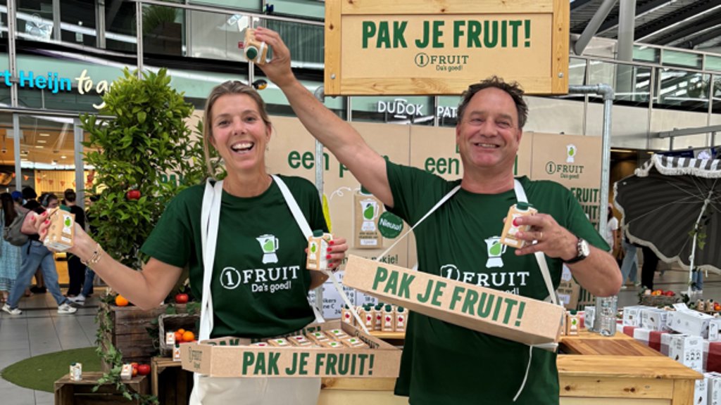 Leonie Kortleve, commercieel directeur Riedel, en Bas Boswinkel, algemeen directeur Riedel, sampelen de ‘nieuwe generatie sap’ – 1FRUIT – op Utrecht CS. Een pakje 1FRUIT bevat exact dezelfde hoeveelheid vitaminen, fruitsuiker, kalium en vezels als resp. één appel, peer of sinaasappel.