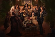 The full RHOA cast standing in an ornate room with brown decor.