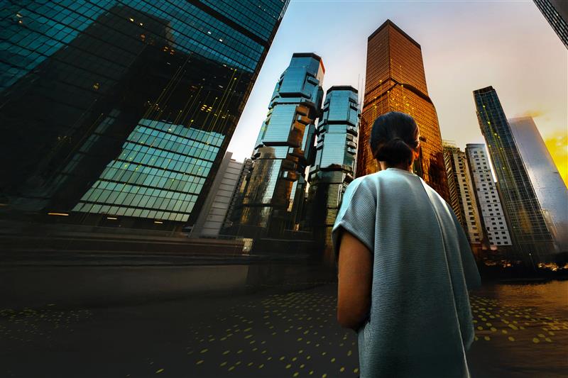 Asian businesswoman standing against contemporary corporate skyscrapers