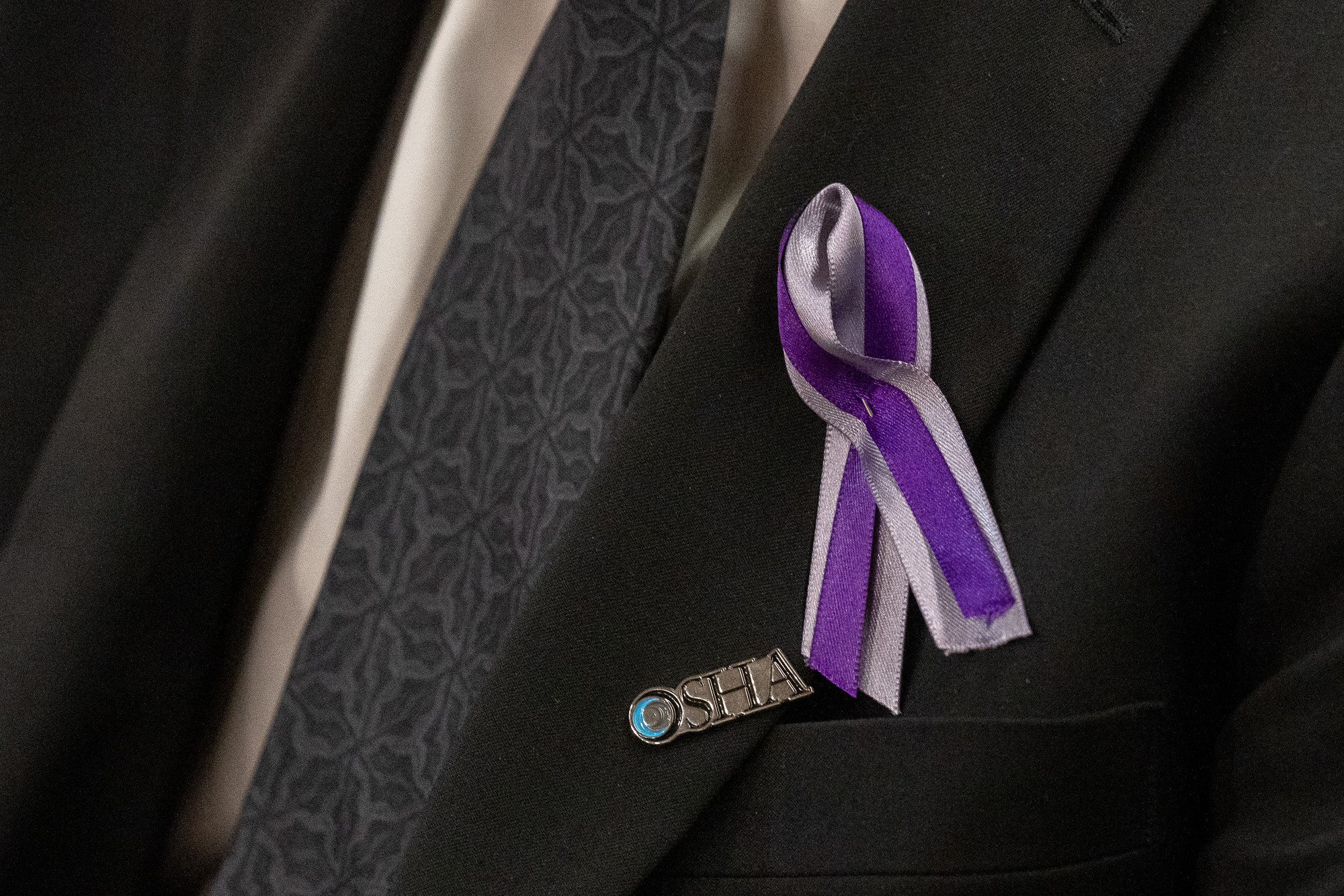 Clopseup of purple ribbon pinned to suit blazer