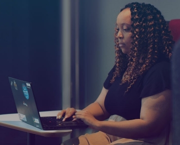 Person sitting and typing on a laptop